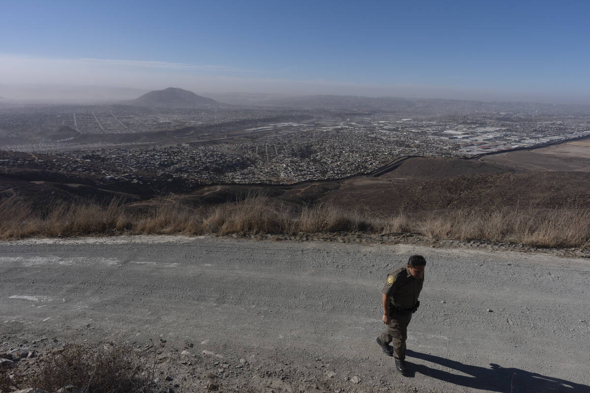 Border Patrol Agent Gutierrez walks along a road near where two border walls separate Mexico fr ...