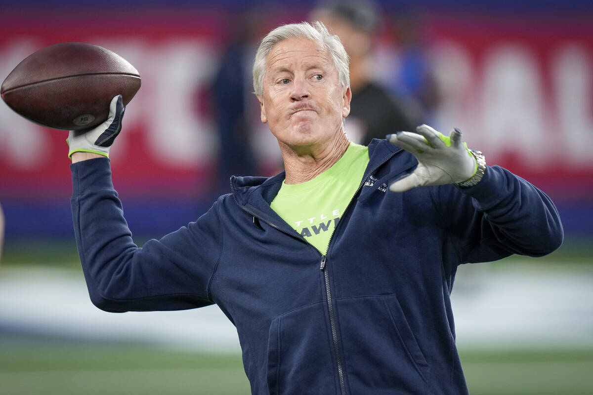 Seattle Seahawks head coach Pete Carroll throws a ball on the sideline before an NFL football g ...