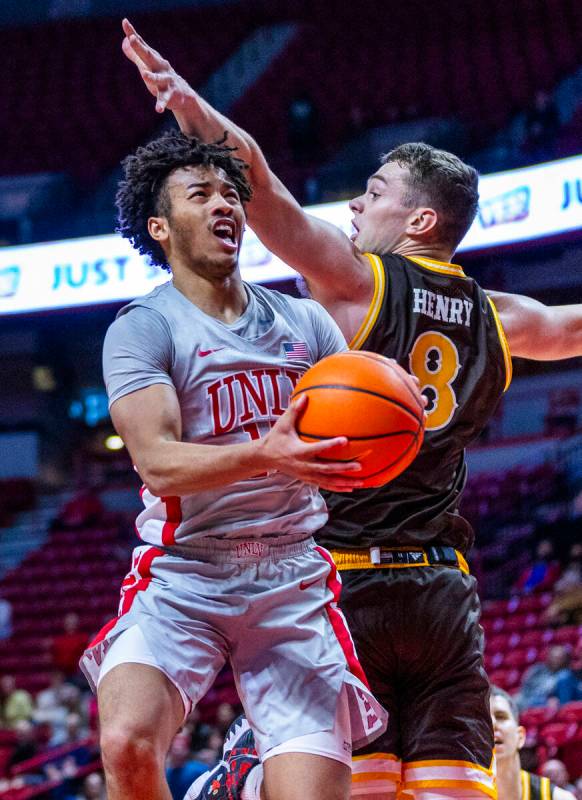 UNLV guard Dedan Thomas Jr. (11) gets underneath of Wyoming Cowboys forward Cole Henry (8) for ...