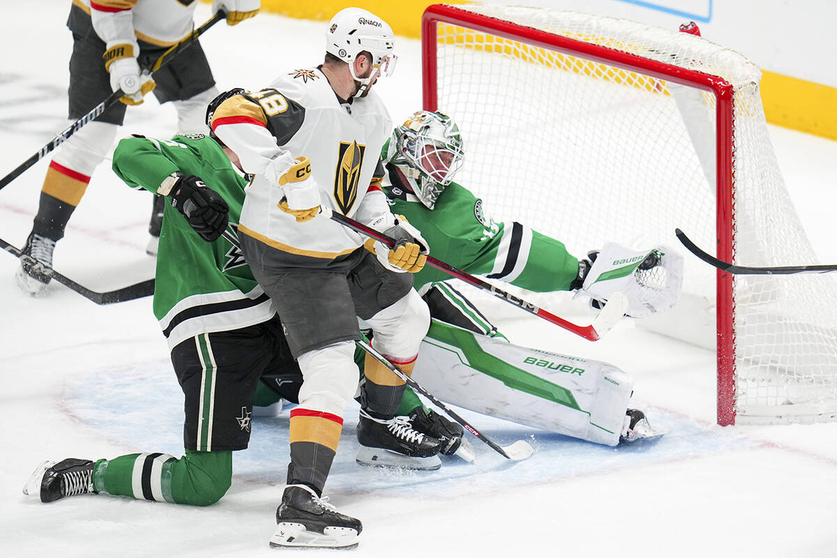 Dallas Stars goaltender Jake Oettinger, back right, gloves a shot by Vegas Golden Knights left ...