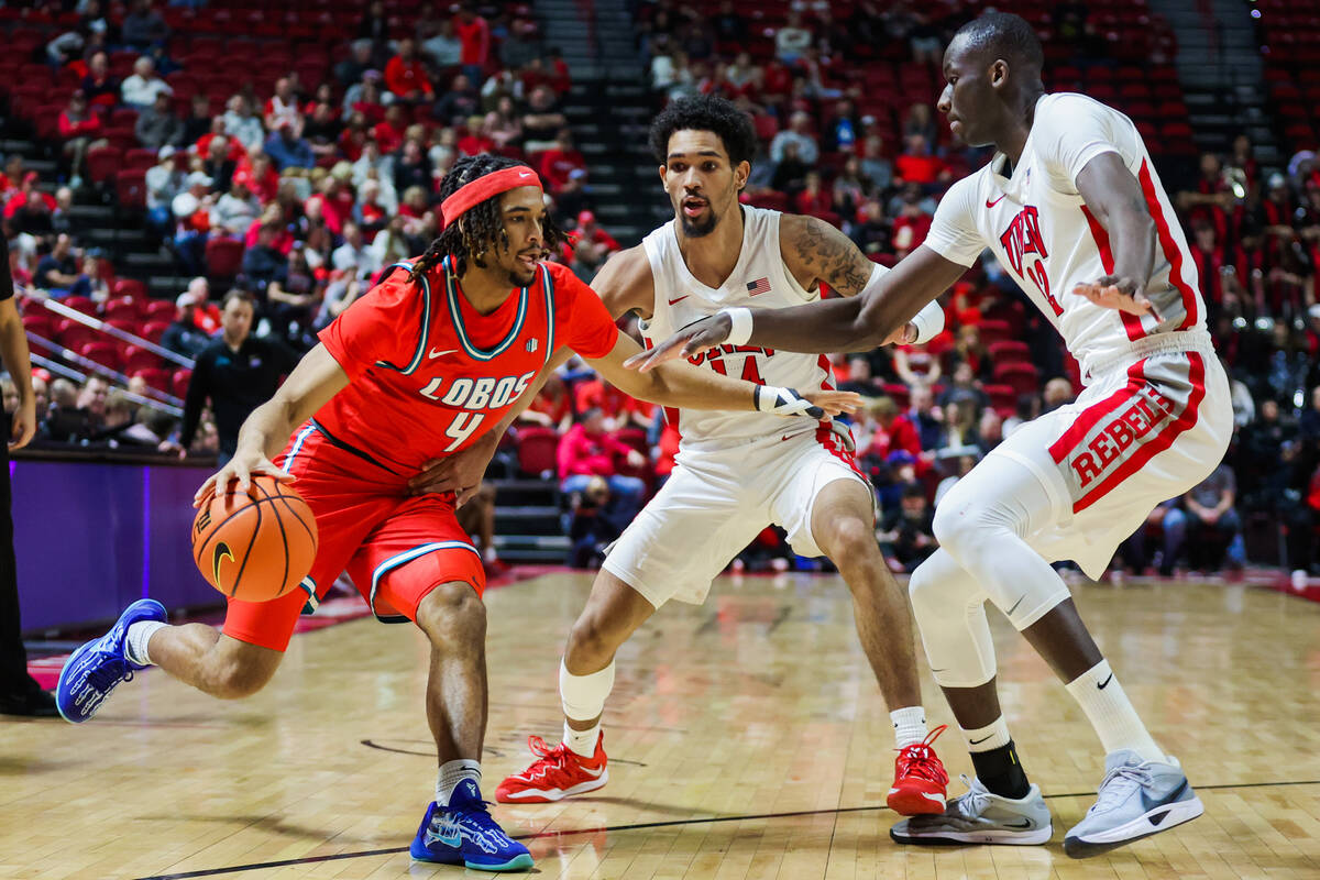 New Mexico Lobos guard Kayde Dotson (4) tries to drive the ball past Rebels forward Pape N'Diay ...