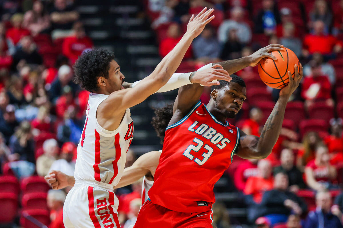 New Mexico Lobos center Nelly Junior Joseph (23) looks for an open teammate as Rebels guard Jai ...