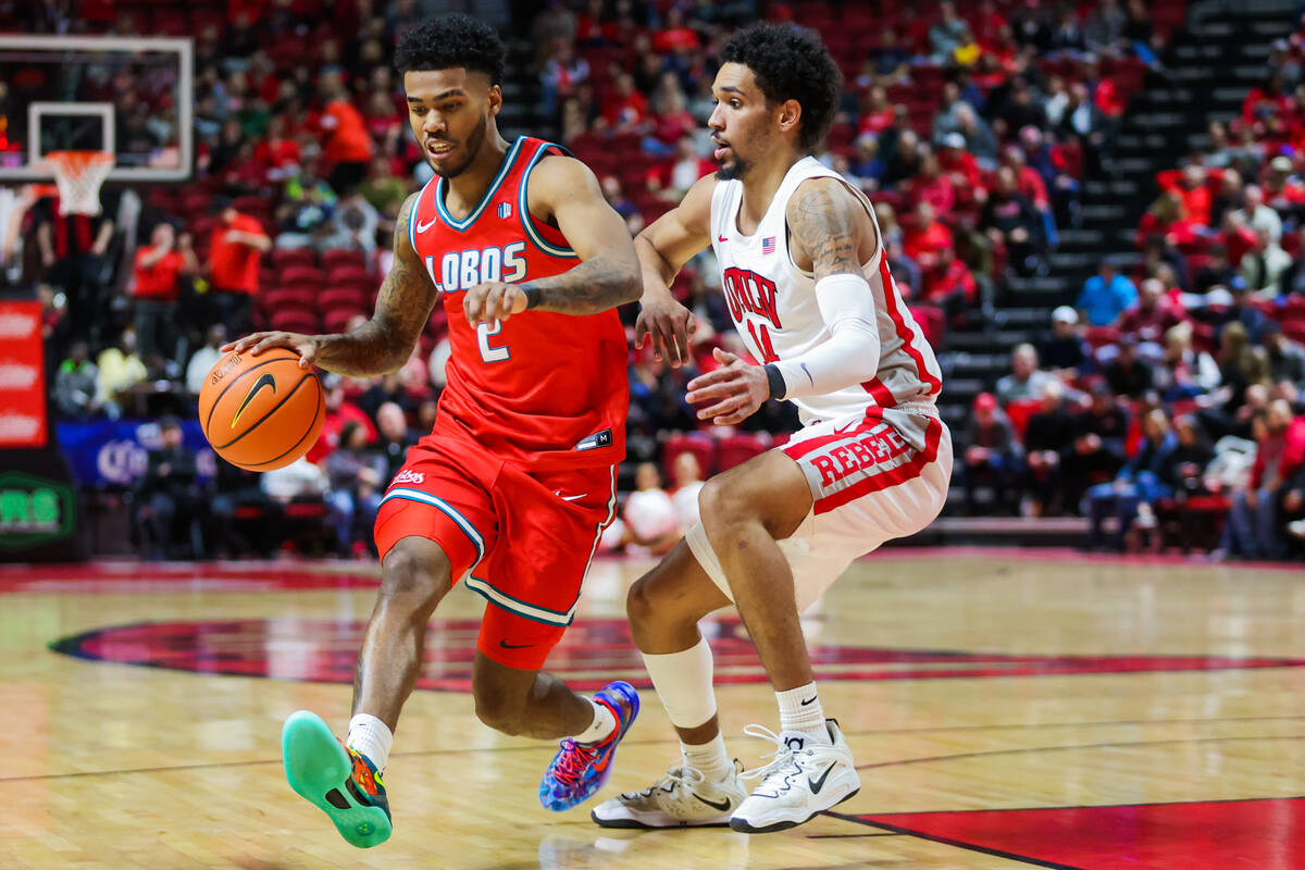 New Mexico Lobos guard Donovan Dent (2) drives the ball as Rebels guard Jailen Bedford (14) gua ...