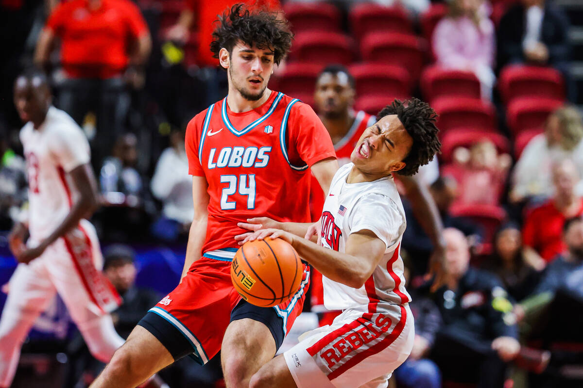 Rebels guard Dedan Thomas Jr. (11) reacts to an impact by New Mexico Lobos forward Jovan Milice ...