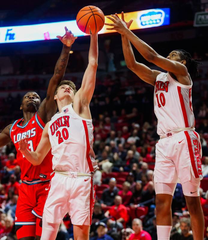 Rebels guard Julian Rishwain (20), Rebels guard Jaden Henley (10) and New Mexico Lobos forward ...