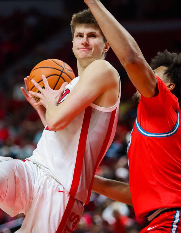 Rebels guard Julian Rishwain (20) goes up for a layup during an NCAA basketball game between th ...