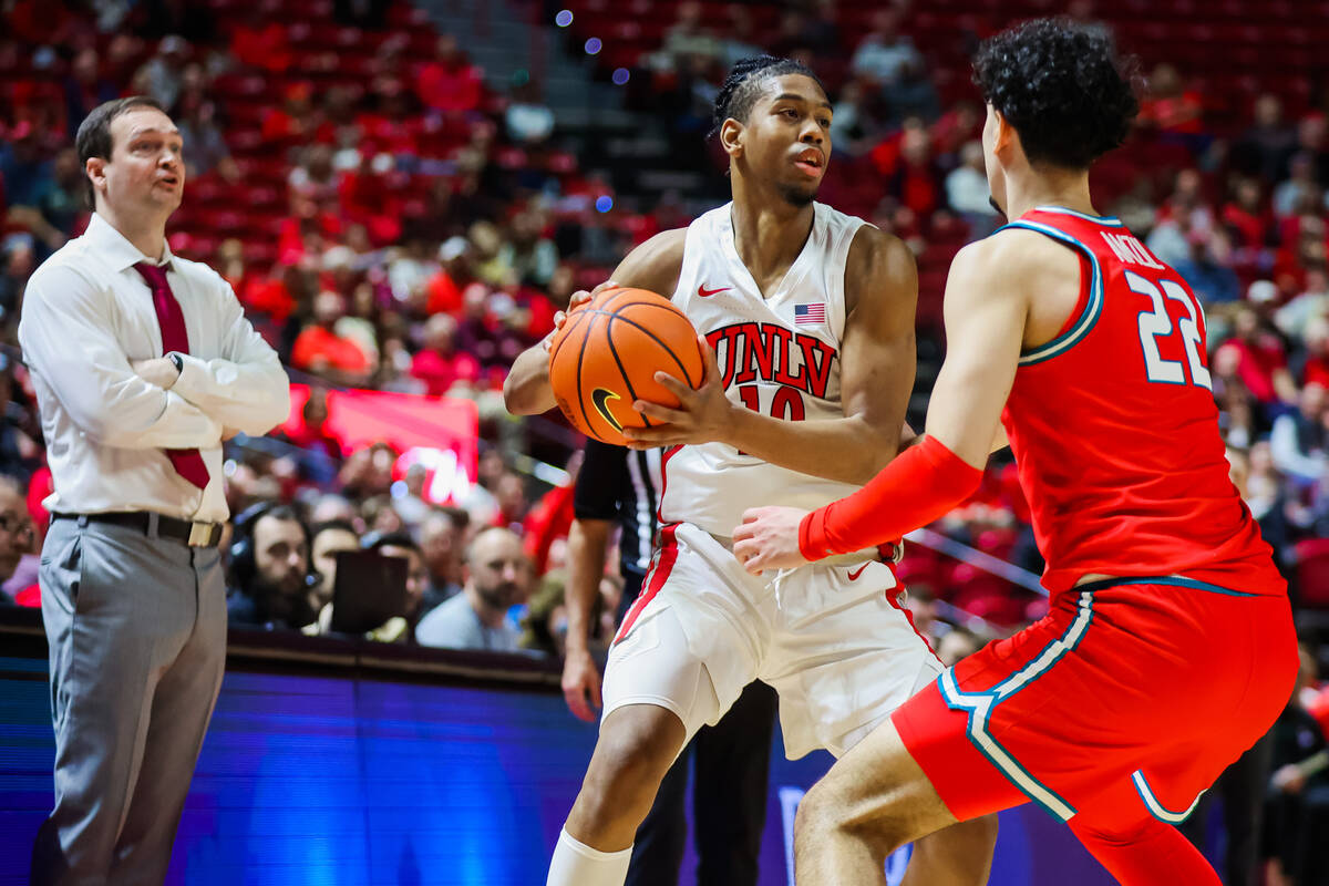 Rebels guard Jaden Henley (10) looks for an opening as New Mexico Lobos forward Mustapha Amzil ...