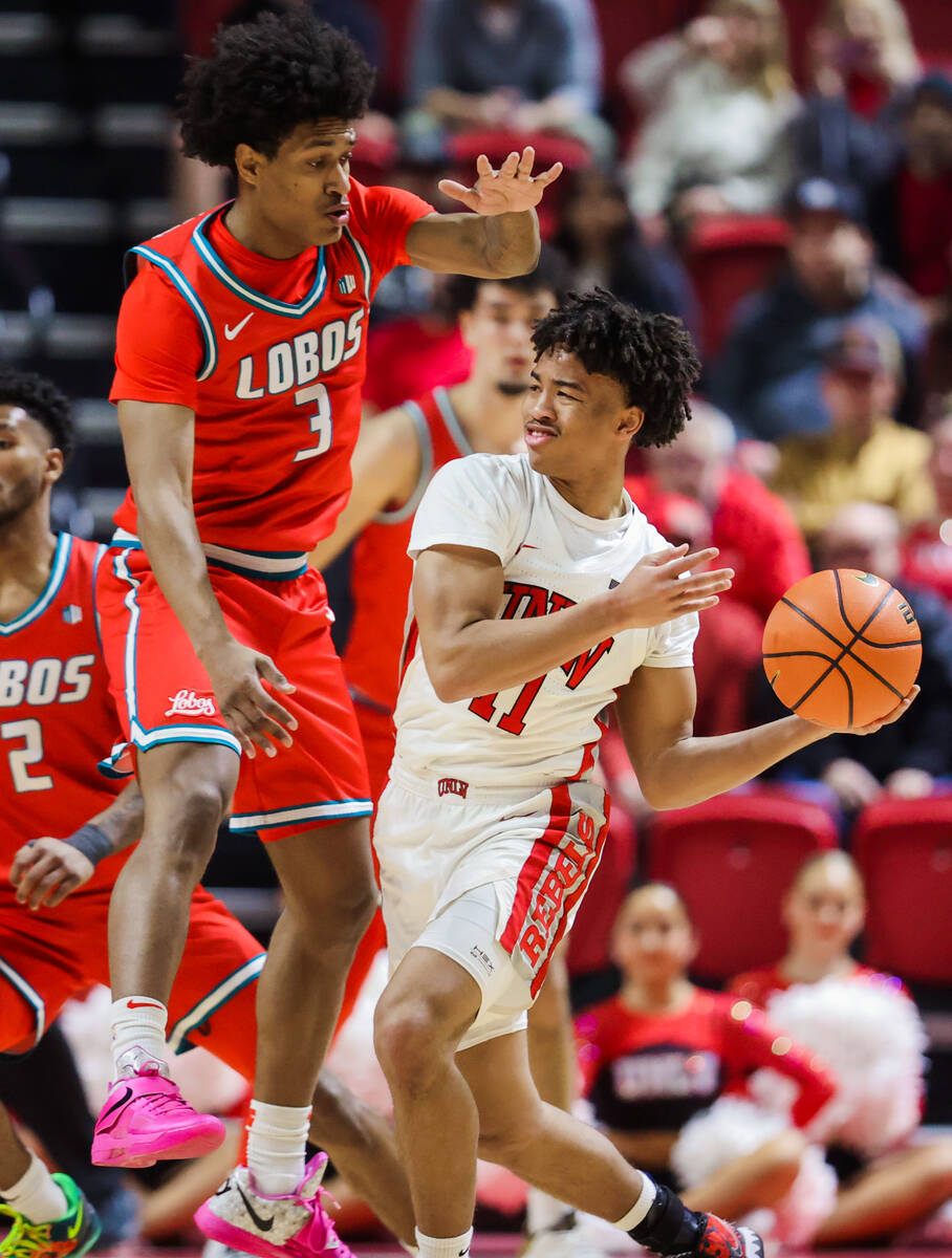 Rebels guard Dedan Thomas Jr. (11) tries to pass the ball to a teammate as New Mexico Lobos gua ...