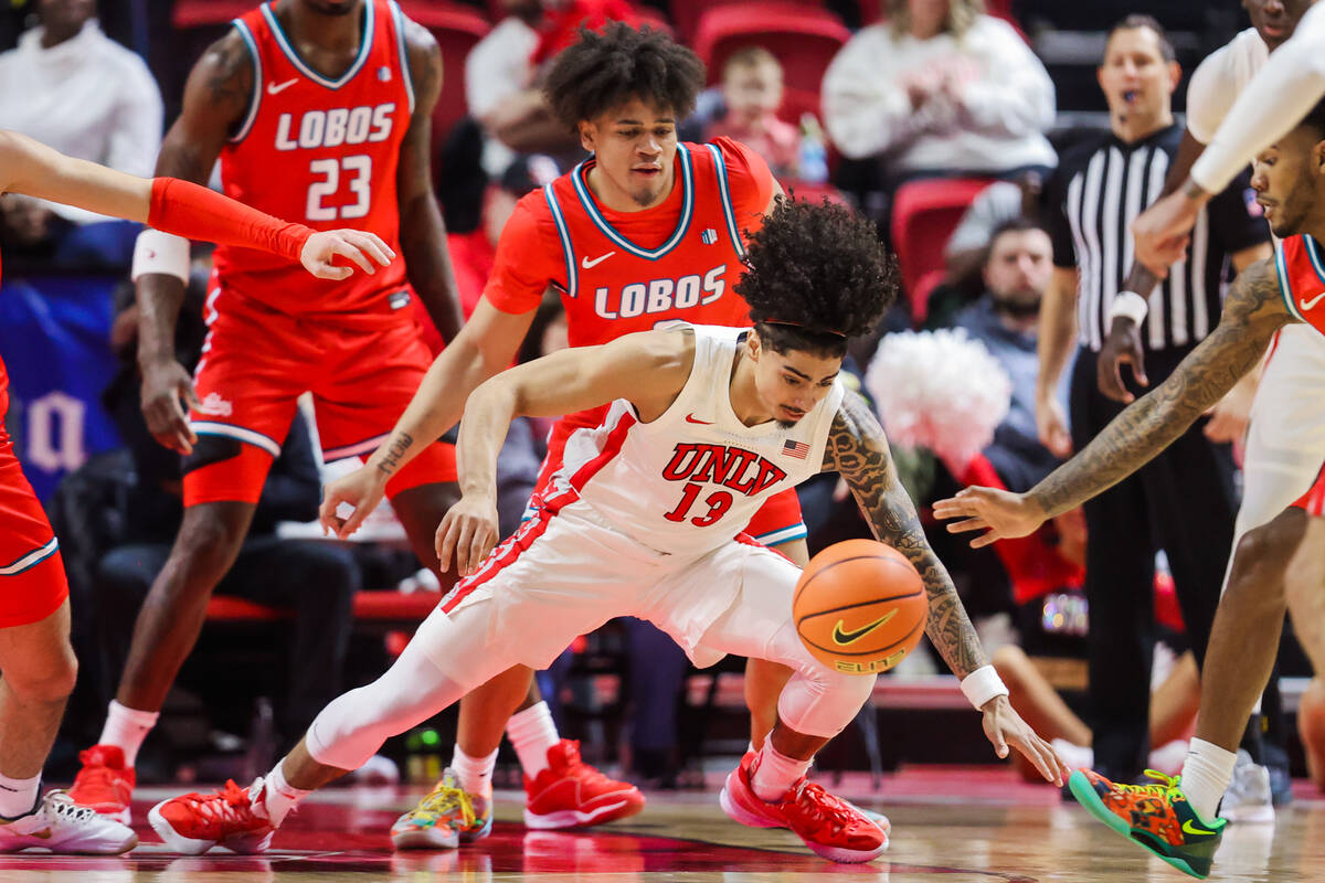 Rebels guard Brooklyn Hicks (13) falls as he chases the ball during an NCAA basketball game bet ...