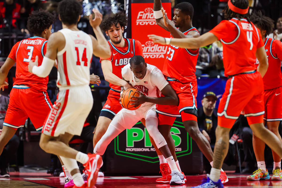 Rebels forward Pape N'Diaye (22) gets caught up in New Mexico Lobos defense while working the p ...