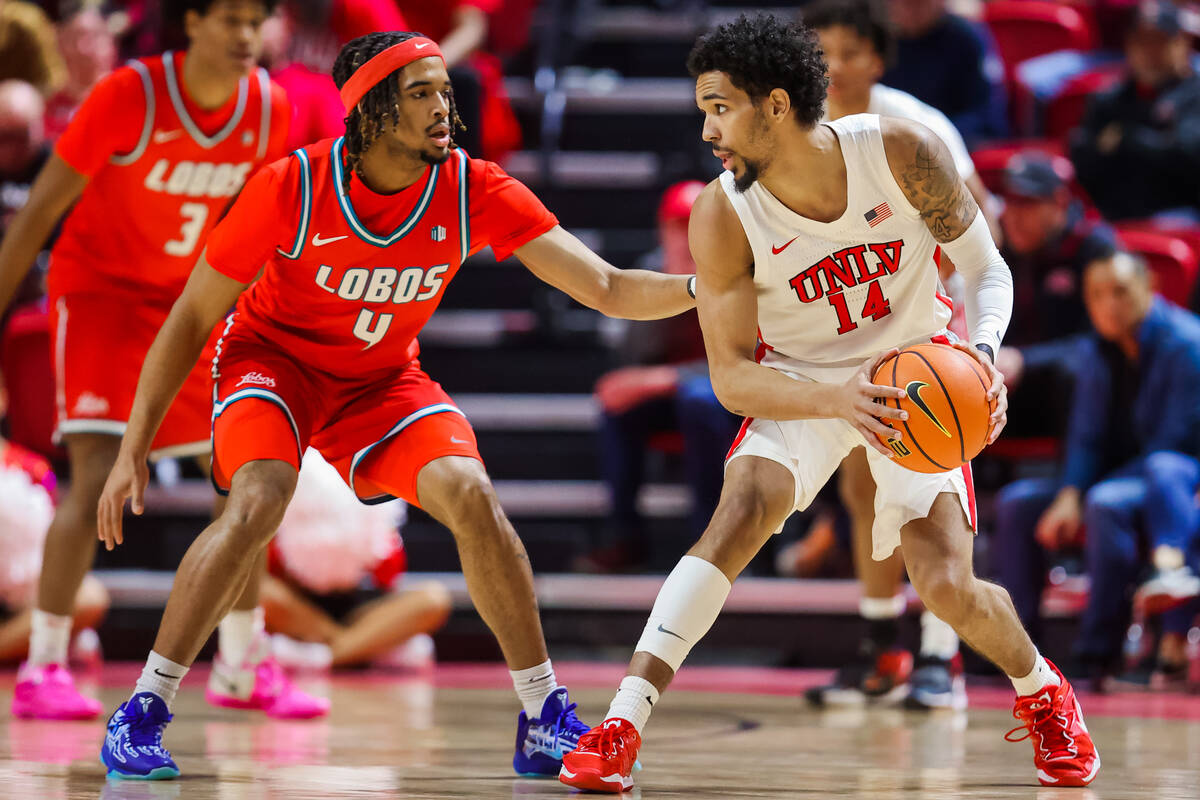 Rebels guard Jailen Bedford (14) looks for a path forward with the ball as New Mexico Lobos gua ...