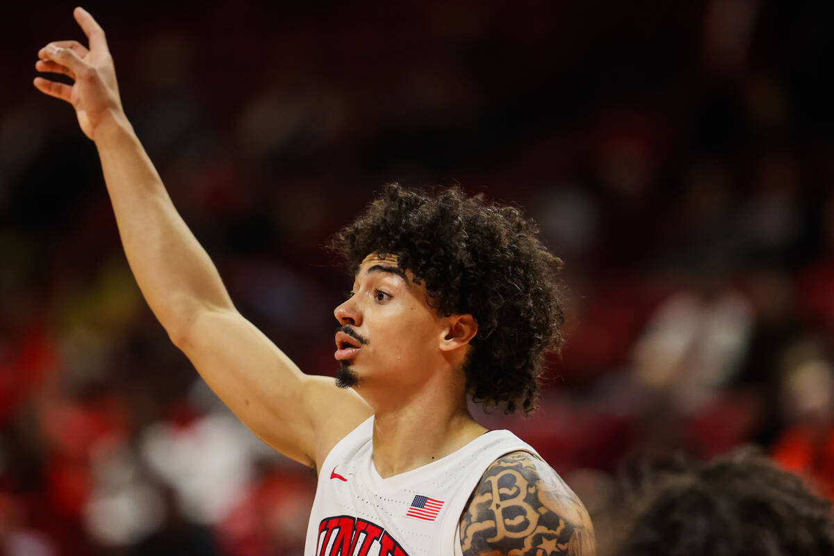 Rebels guard Brooklyn Hicks signals to a teammate during an NCAA basketball game between the Re ...