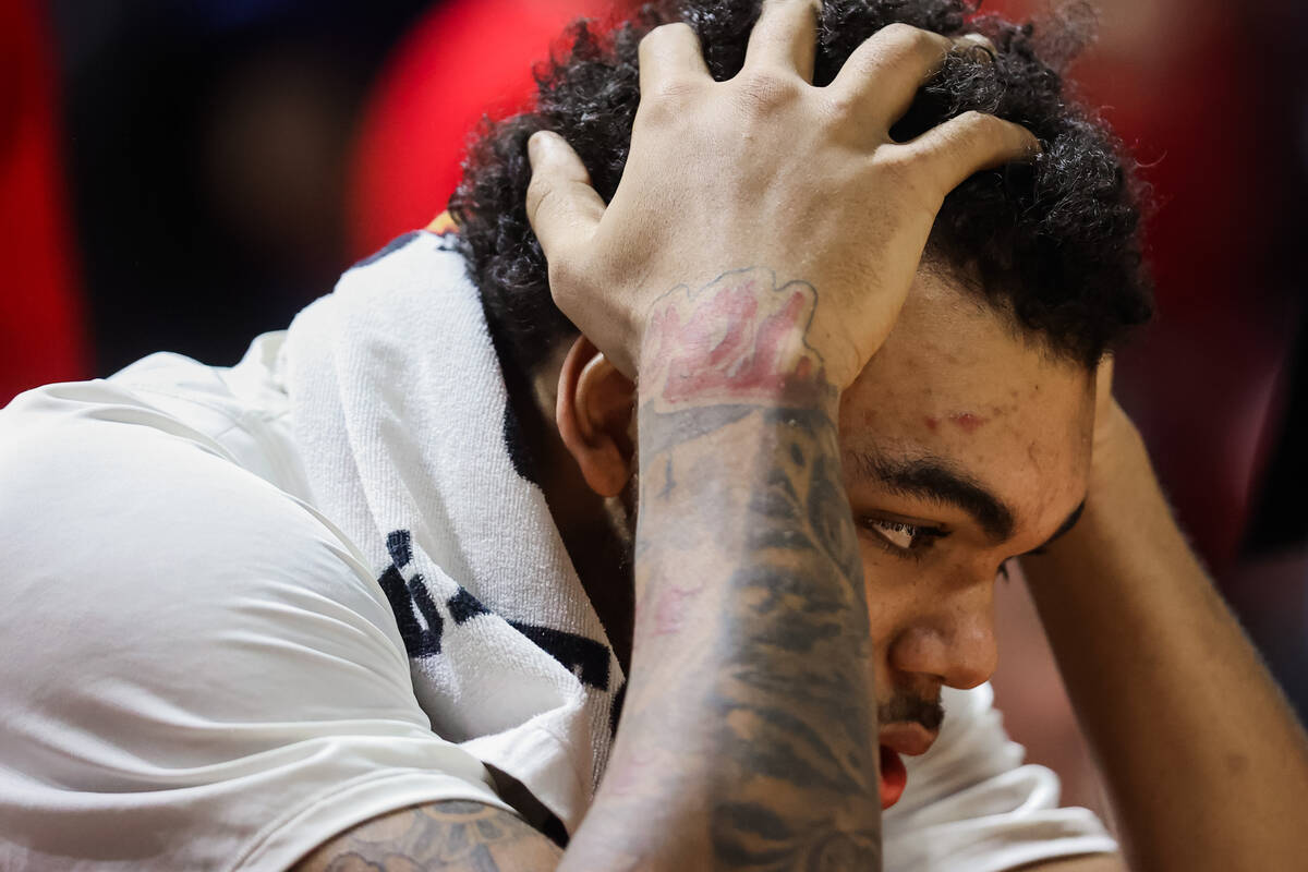 Rebels forward Jeremiah Cherry holds his head in his hands during a time out at an NCAA basketb ...