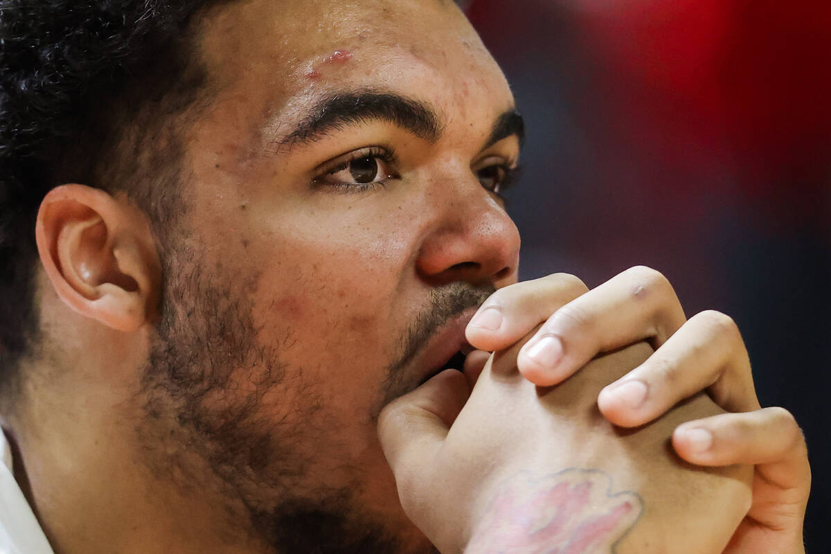 Rebels forward Jeremiah Cherry watches game action from the sidelines during an NCAA basketball ...