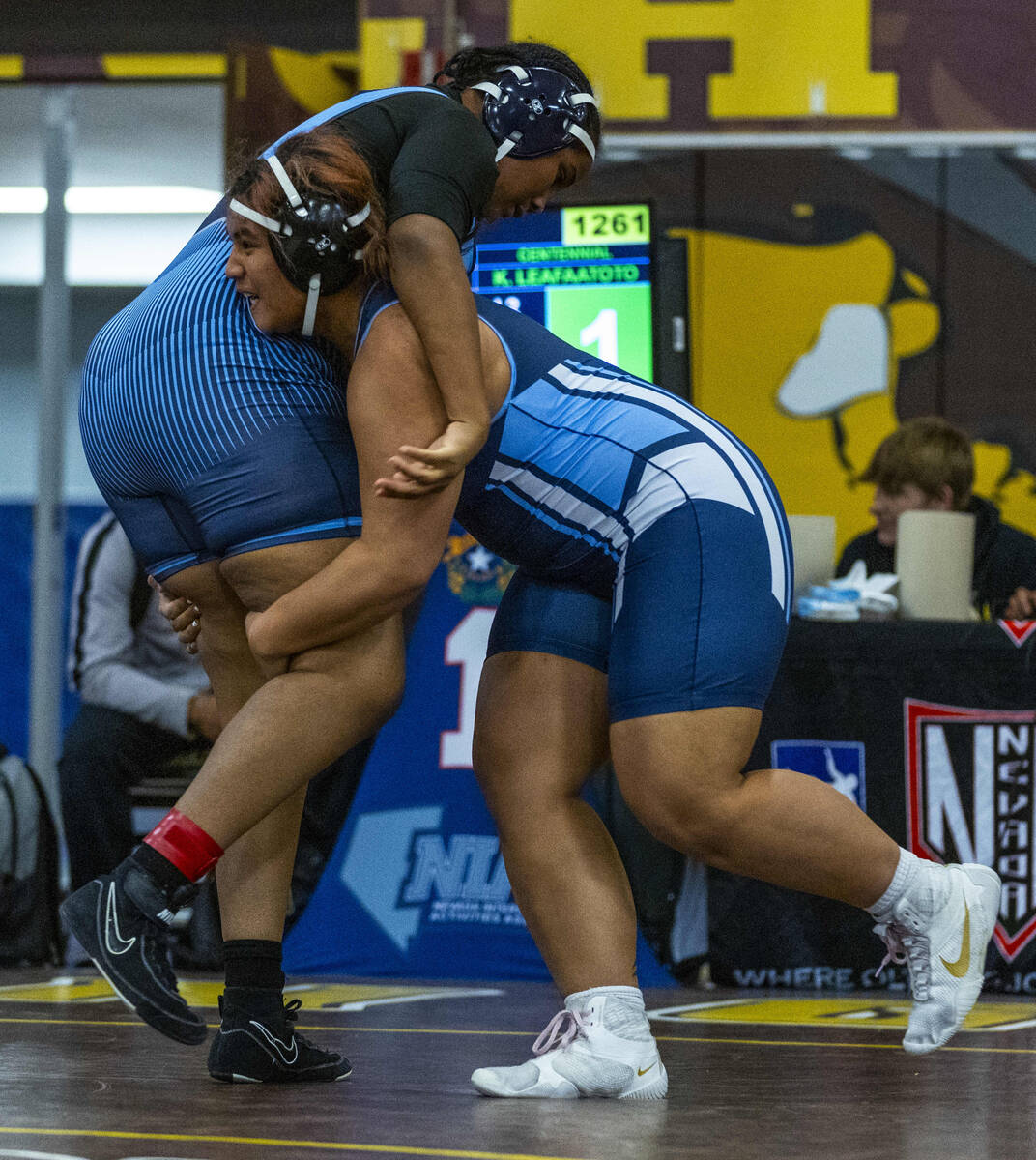 Canyon Springs’ Isabella Gray is lifted up by Centennial’s Kitana Leafaatoto duri ...