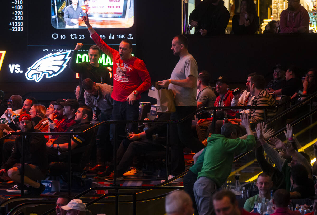 People celebrate after a play during the NFC championship football game at the Circa sportsbook ...