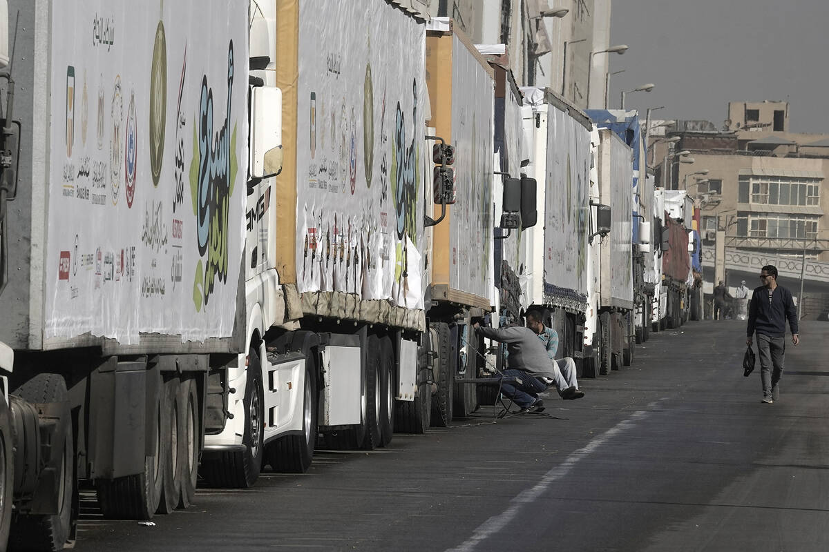 Truck drivers of humanitarian aid wait at a parking point in Cairo, Egypt, on their way to cros ...