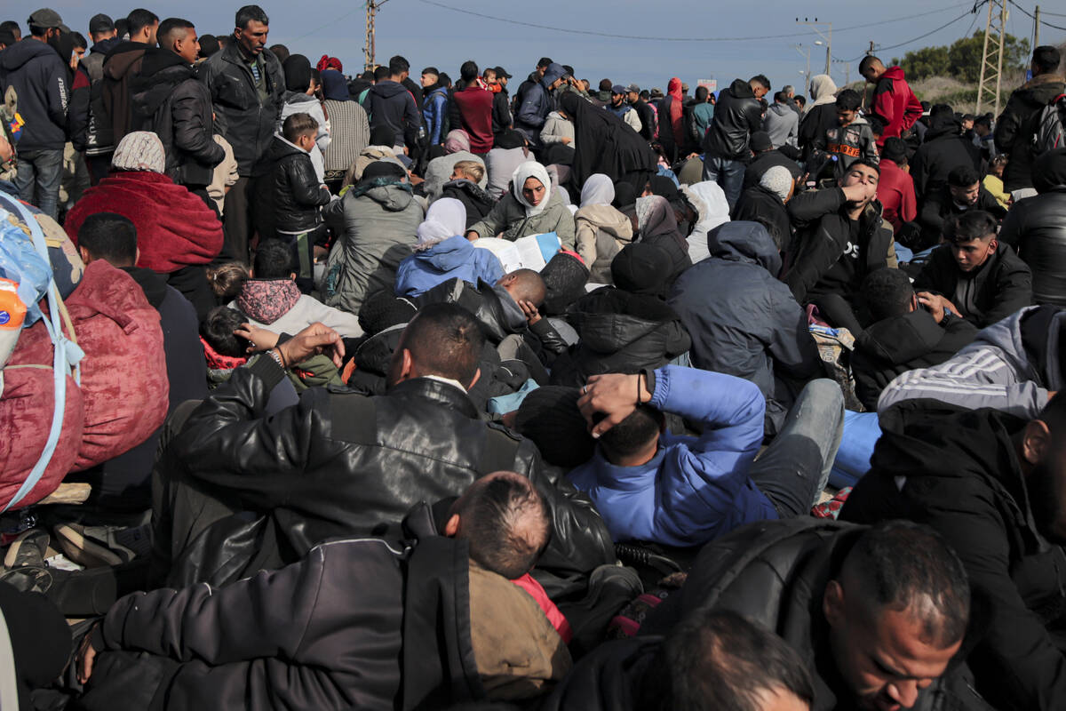 Displaced Palestinians gather with their belongings near a roadblock on the al Rashid Street, a ...