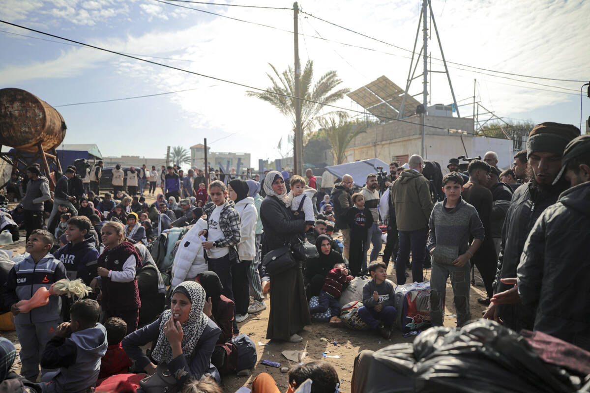 Displaced Palestinians gather with their belongings near a roadblock on the al Rashid Street, a ...