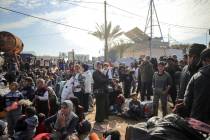 Displaced Palestinians gather with their belongings near a roadblock on the al Rashid Street, a ...