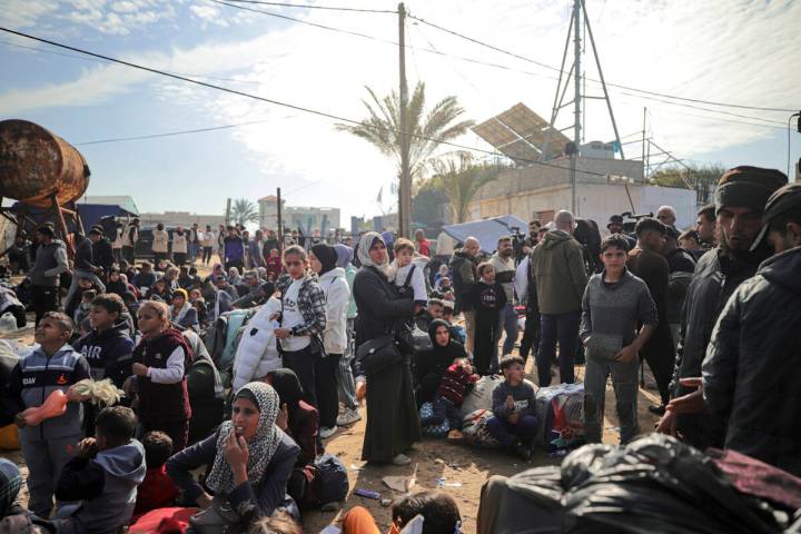 Displaced Palestinians gather with their belongings near a roadblock on the al Rashid Street, a ...