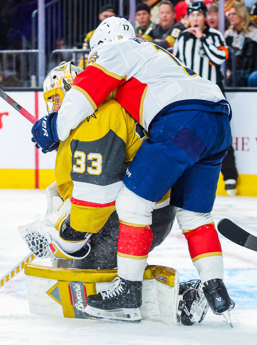 Florida Panthers center Evan Rodrigues (17) balances himself on Golden Knights goaltender Adin ...