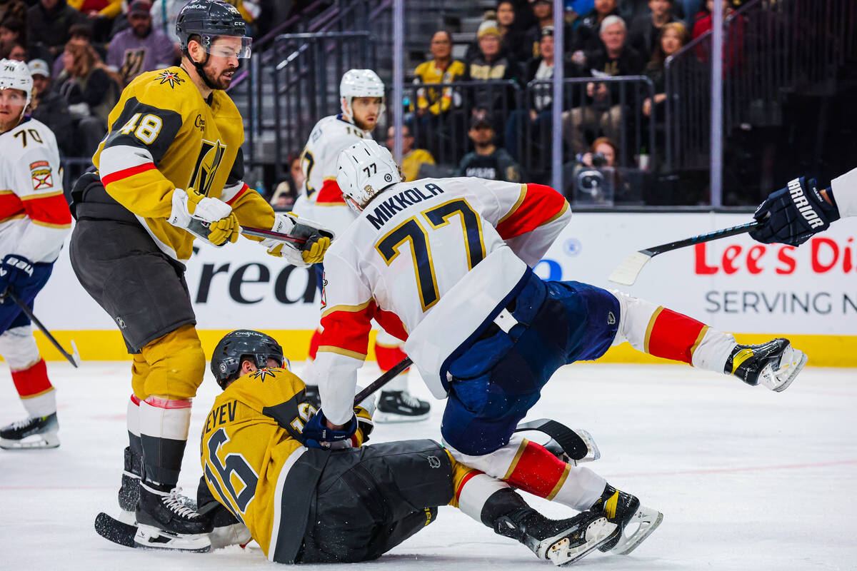 Florida Panthers defenseman Niko Mikkola (77) falls on top of Golden Knights left wing Pavel Do ...