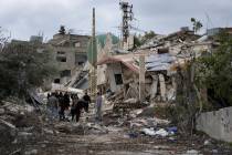 Lebanese citizens check the destruction in their village caused by the Israeli air and ground o ...