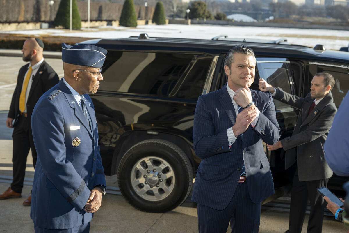 Defense Secretary Pete Hegseth, center right, shows his bracelet as he is welcomed to the Penta ...