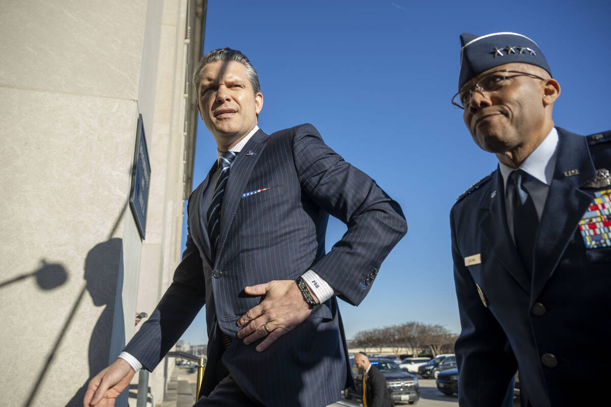 Defense Secretary Pete Hegseth walks into the Pentagon with Chairman of the Joint Chiefs of Sta ...