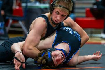 SLAM's Isaac Balden works to pin Basic's Jaxon Mackey during their 150 lb. finals match in the ...