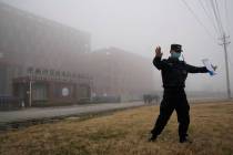 A security person moves journalists away from the Wuhan Institute of Virology after a World Hea ...