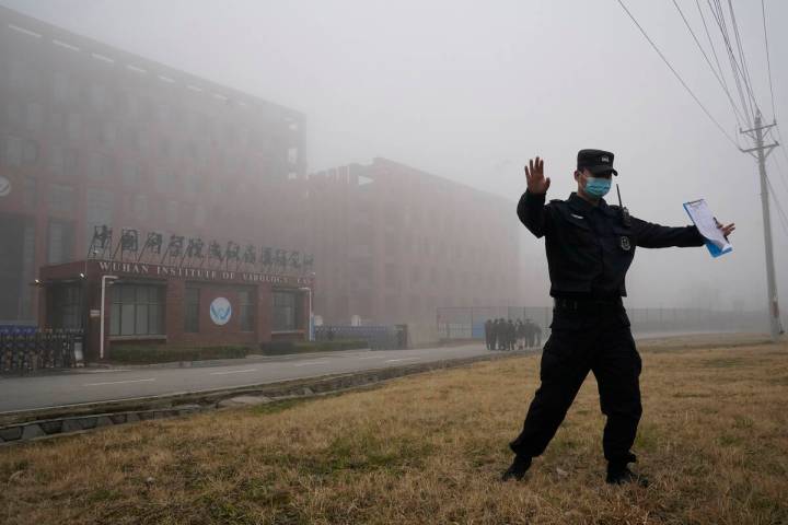 A security person moves journalists away from the Wuhan Institute of Virology after a World Hea ...