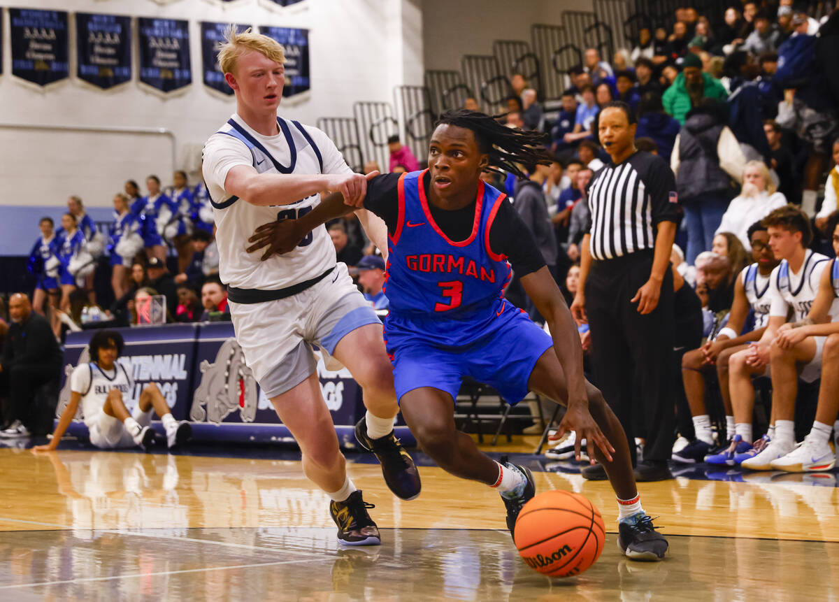 Bishop Gorman guard Ty Johnson (3) drives to the basket against Centennial's Cooper Jenkins (30 ...