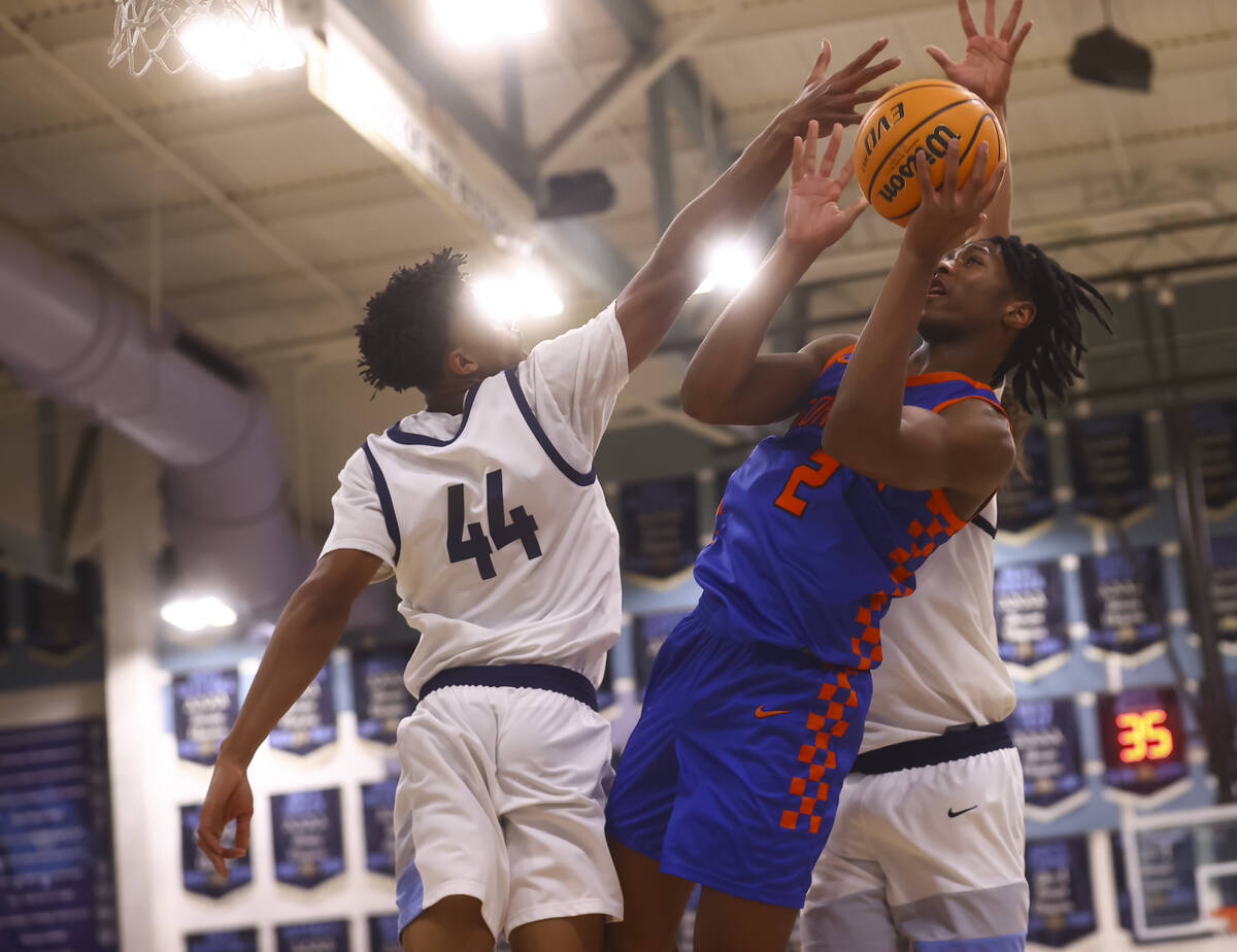 Bishop Gorman's Jett Washington (2) shoots under pressure from Centennial's Bryce Iwuoha (44) d ...