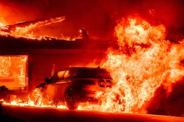 A car and home burn during the Eaton fire in the Altadena area of Los Angeles County, Californi ...