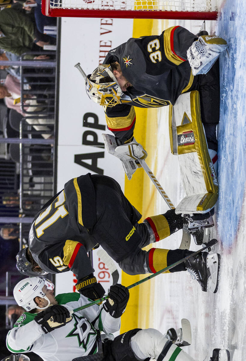 Golden Knights goaltender Adin Hill (33) loses his helmet as he goes to the ice to save a goal ...