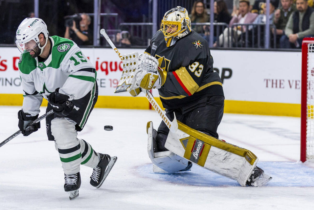 Golden Knights goaltender Adin Hill (33) deflects as shot as it passes Dallas Stars center Coli ...