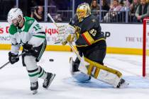 Golden Knights goaltender Adin Hill (33) deflects as shot as it passes Dallas Stars center Coli ...