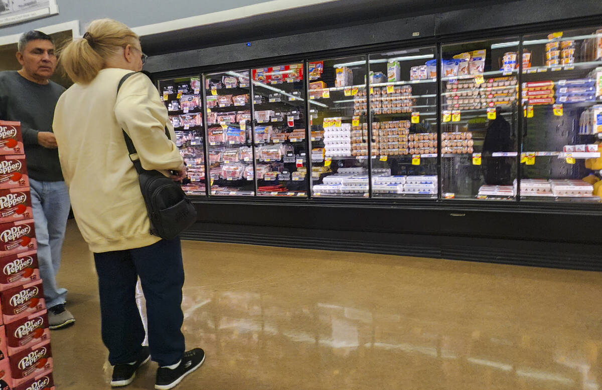 A woman looks at eggs, which have been subject to rising prices, before moving on without them ...