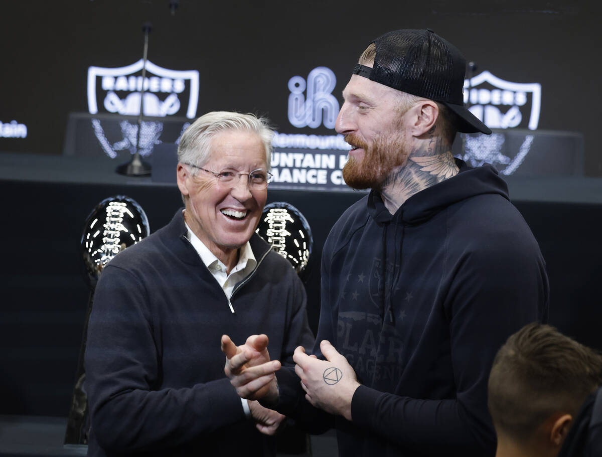 The new Raiders head coach Pete Carroll, left, and defensive end Max Crosby share laughter afte ...