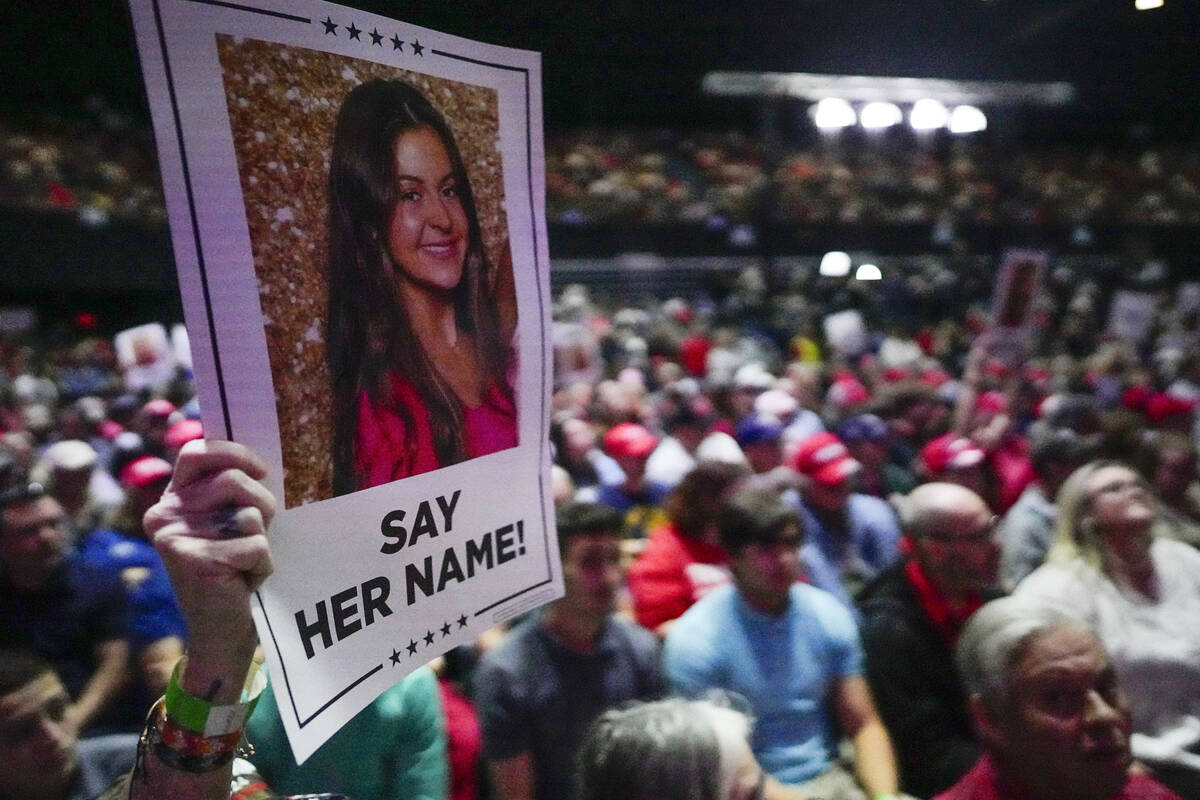 A supporter holds a poster with a photo of Laken Riley before Republican presidential candidate ...