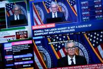 Screens display a news conference by Federal Reserve Chair Jerome Powell on the floor of the Ne ...