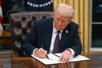 U.S. President Donald Trump signs an executive order in the Oval Office of the White House in W ...