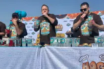 Joey Chestnut, center, competes against Nick Wehry, left, and Patrick Bertoletti in the third a ...