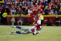 Kansas City Chiefs quarterback Patrick Mahomes (15) tries to avoid a tackle by Buffalo Bills li ...