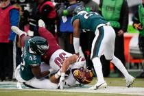 Washington Commanders' Austin Ekeler, center, is tackled by Philadelphia Eagles' Oren Burks, le ...