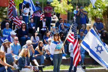 Jennifer Courier, center, holds a U.S. flag while joining others at a rally against antisemitis ...