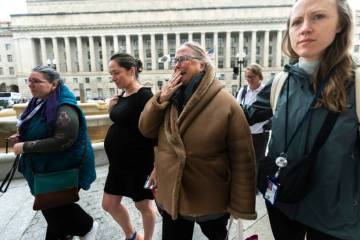 Lucy Mize, second from right, a USAID health officer for 31 years, cries as she walks with fell ...