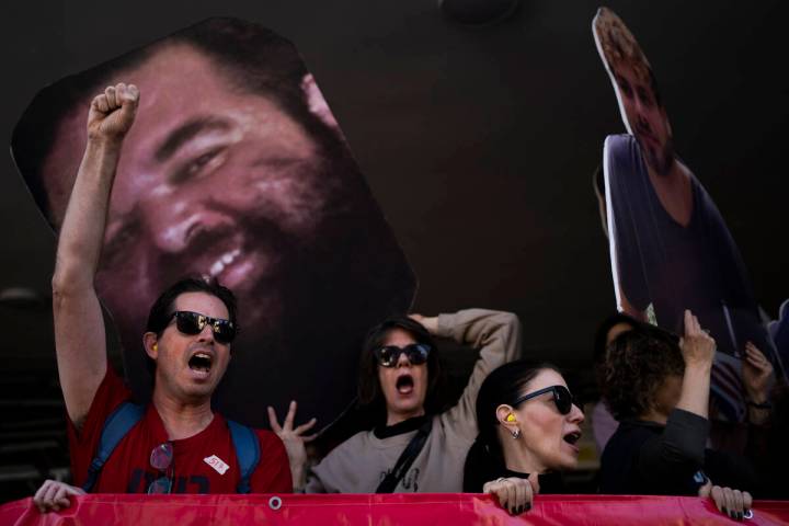 Demonstrators hold photos depicting the faces of Israeli hostages who are being held in the Gaz ...